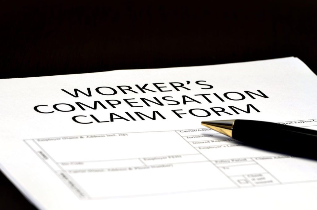 Workers' comp claim form with pen