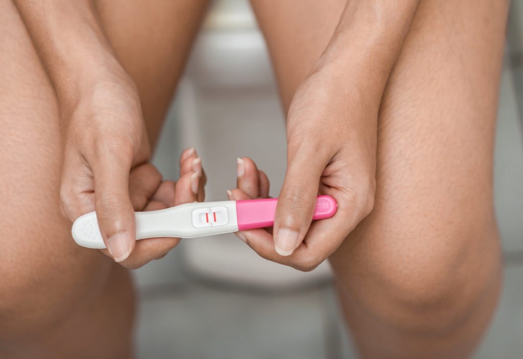 Closeup of positive pregnancy test in woman's hands