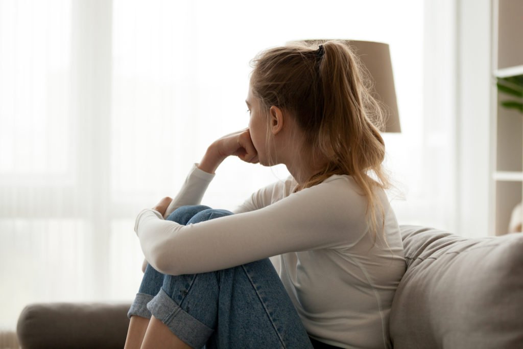 Distraught woman looking out of window