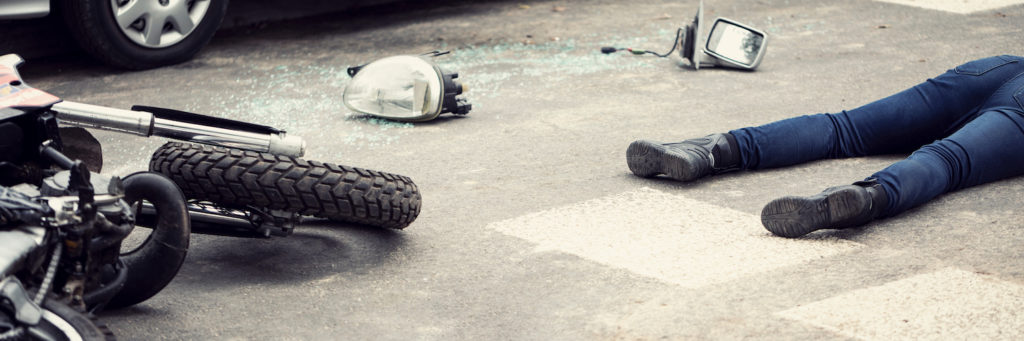 Secuelas de un accidente de motocicleta con una moto accidentada y un cuerpo en la calle
