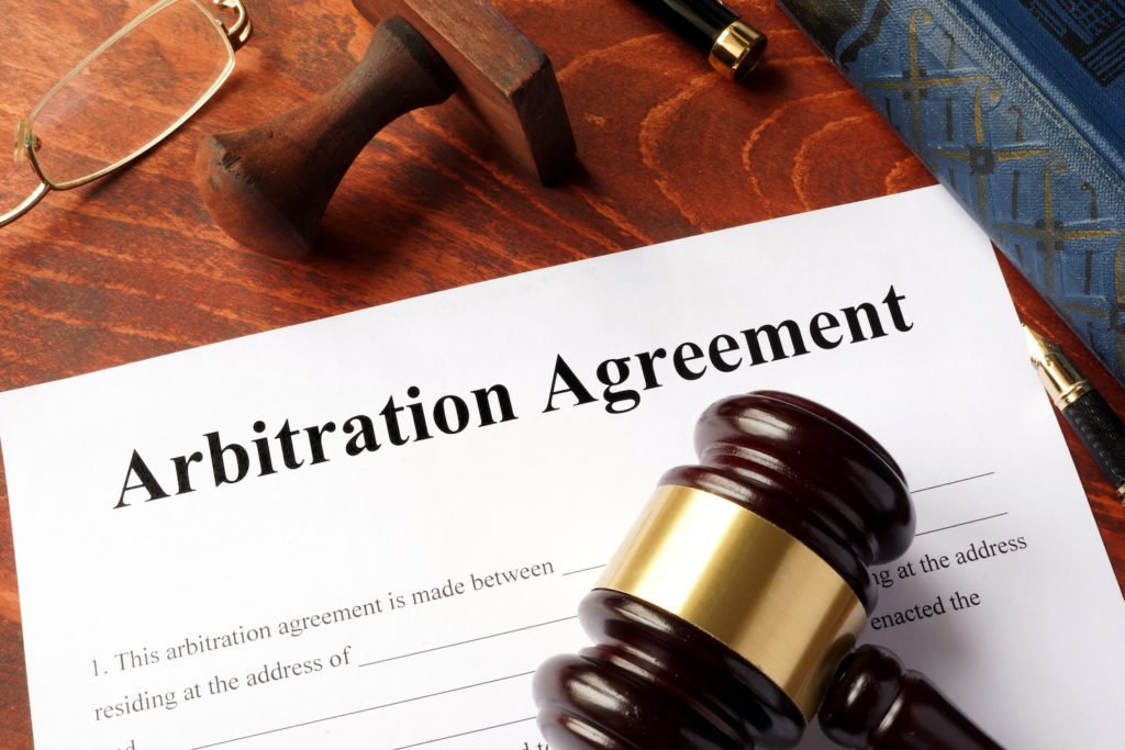 Paper titles "arbitration agreement" underneath a gavel - California law limits when these are enforceable