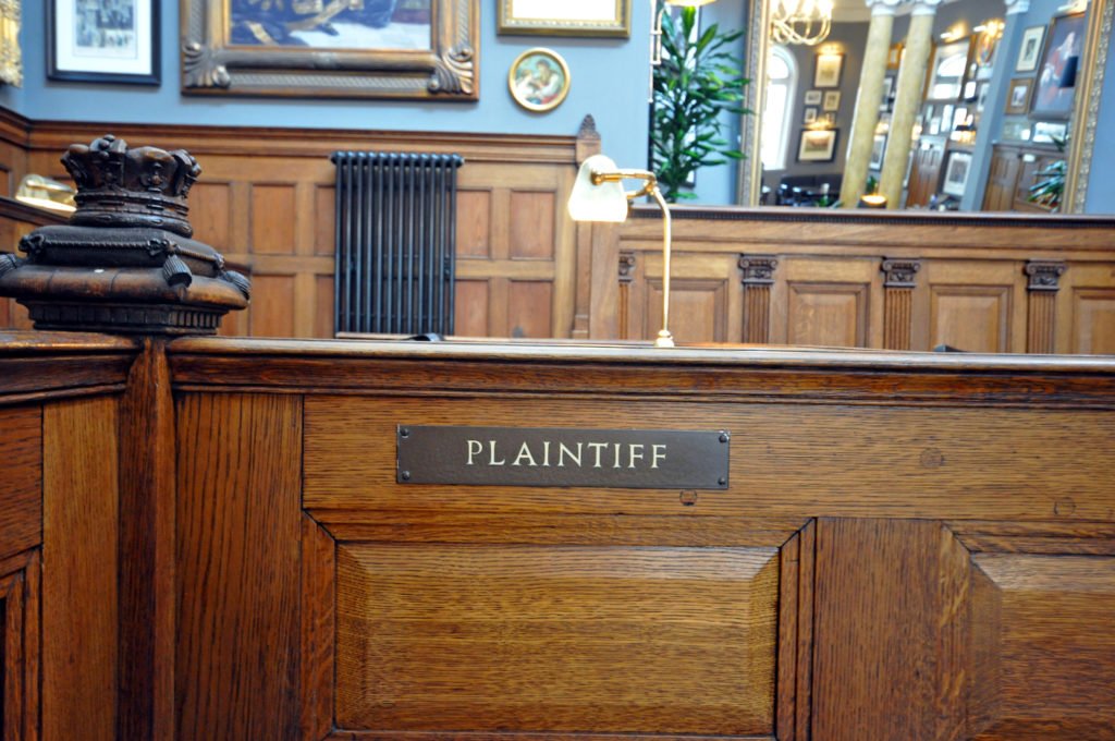 Courtroom with placard that says "plaintiff" - California Class actions lawsuits allow multiple plaintiffs to join together in a single action