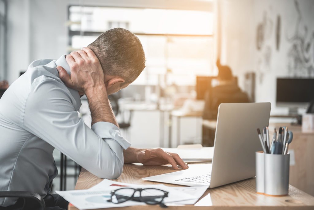 Man at computer with neck ache from sitting