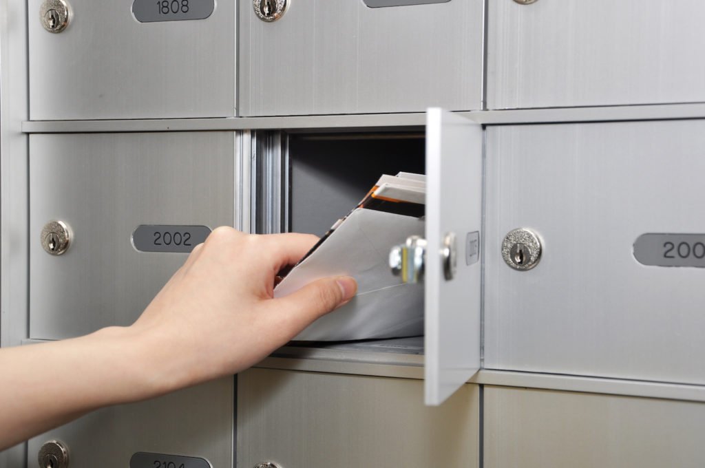 Hand reaching into mailbox to get mail - Penal Code 490.5 PC demand letters are usually sent via U.S. Mail
