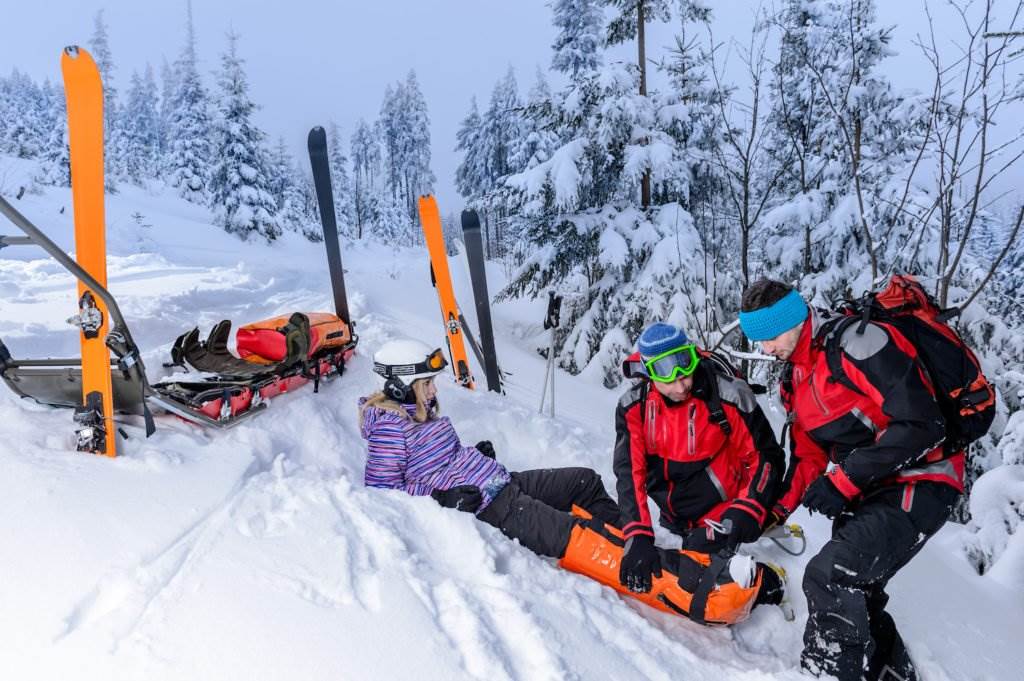 Team of people rescuing skier on slope