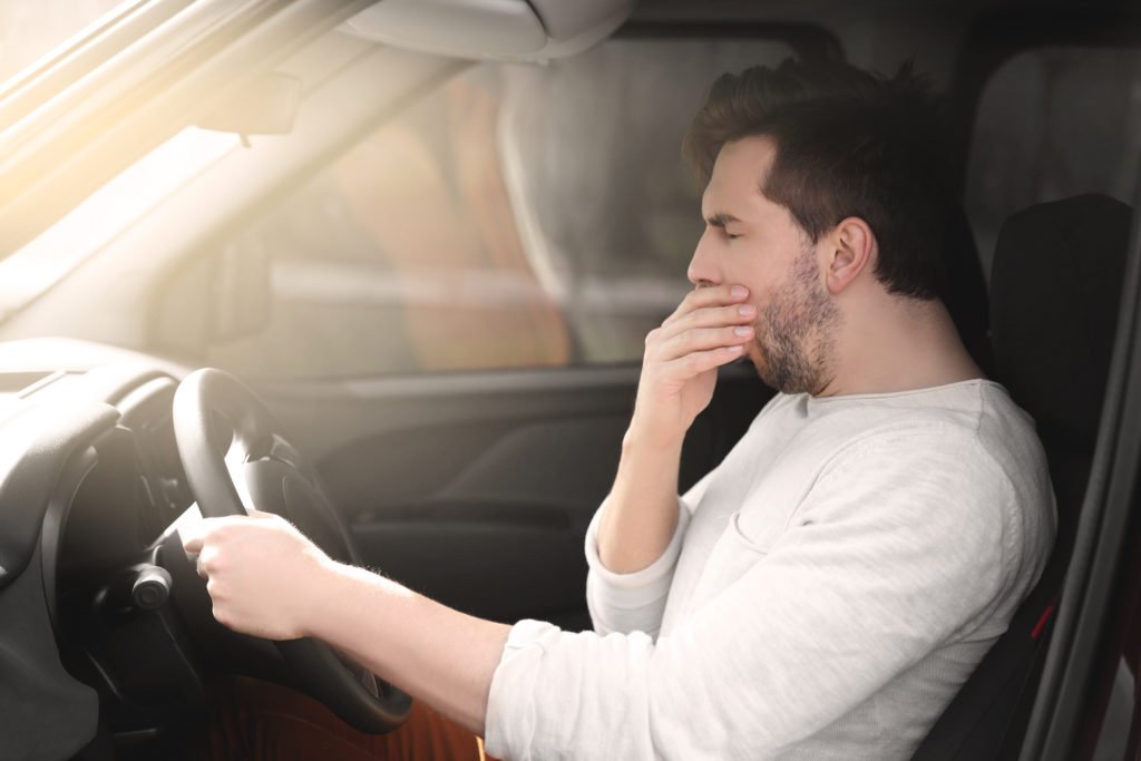 Man yawning while behind the wheel