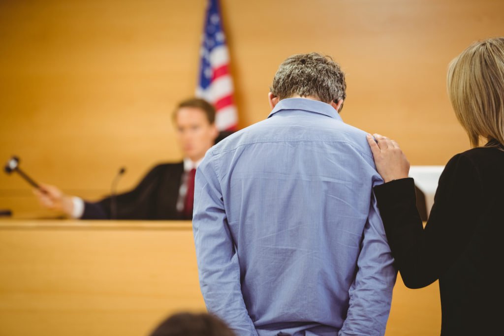 Defendant and his attorney before a judge holding a gavel