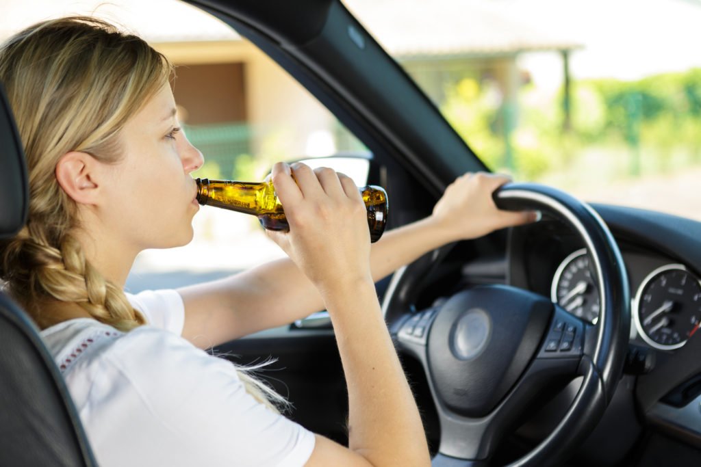 Underage driver drinking beer while driving