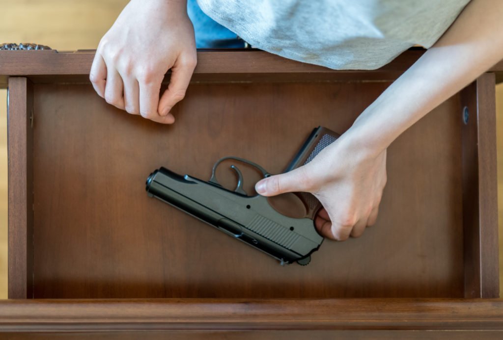 Person taking gun out of drawer