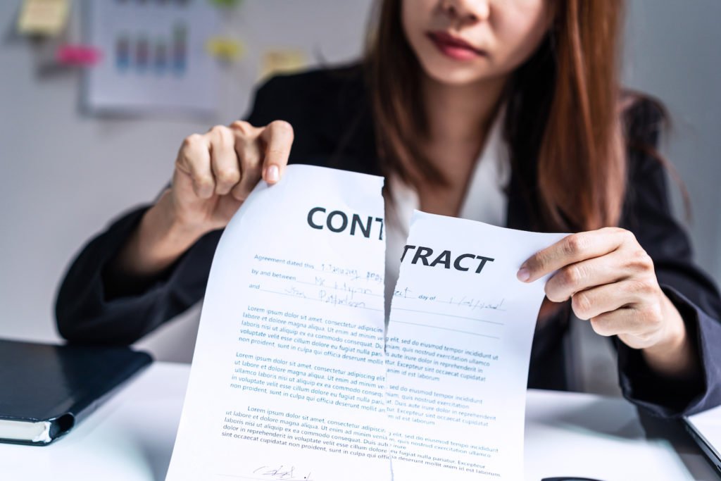 Woman at desk ripping up contract