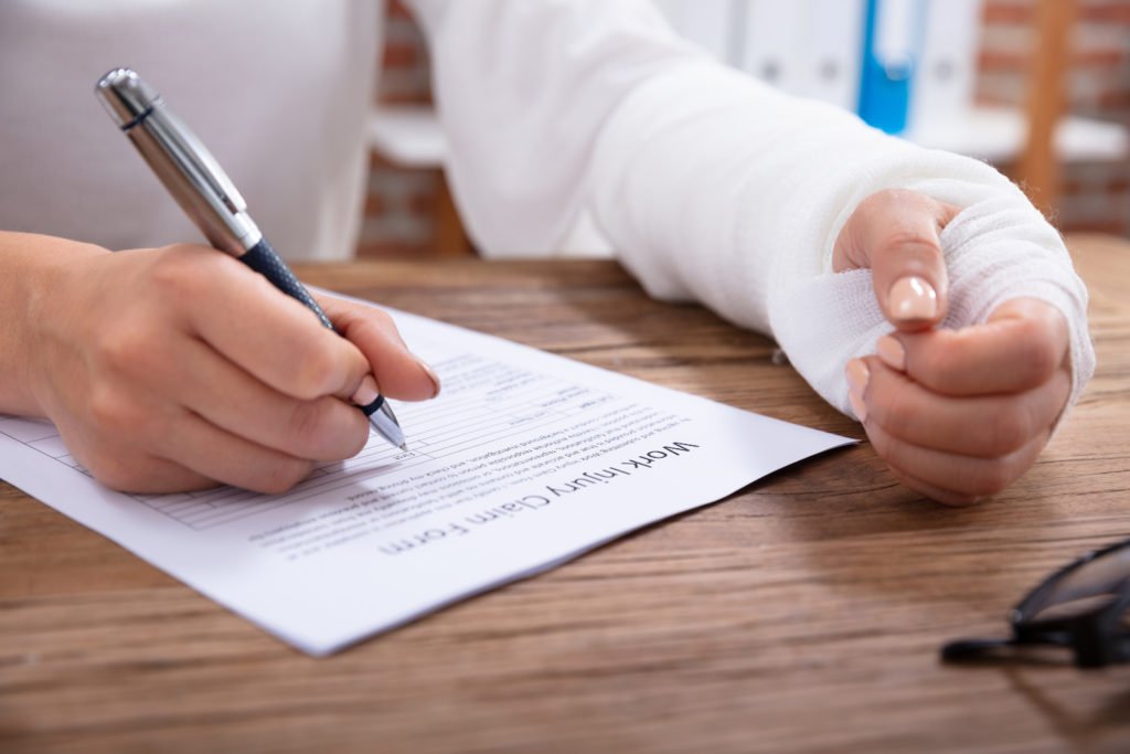 Hand in cast filling out workers comp claim form