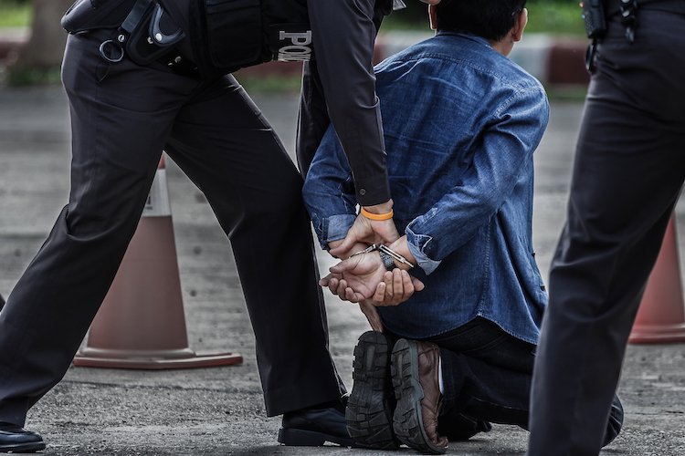 Hombre siendo esposado por un oficial de policía - La ley de extradición de Colorado puede obligar a otros estados a devolver a los fugitivos