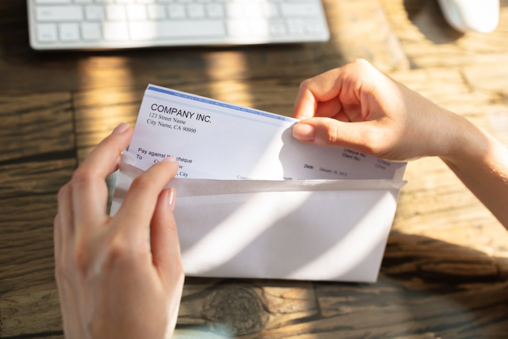 Employee opening an envelope with a paycheck