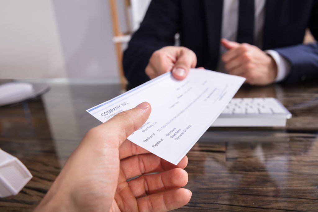 Jefe entregando cheque a trabajador