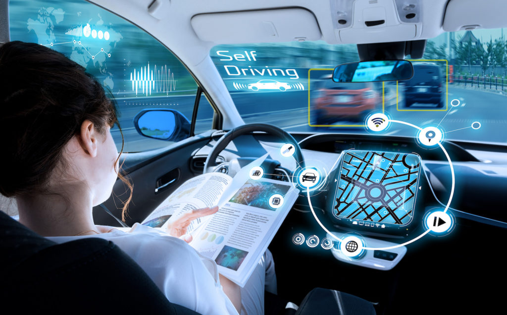 Woman behind wheel of a driverless car on the street - A California self-driving car accident lawyer can help to recover damages stemming from a collision