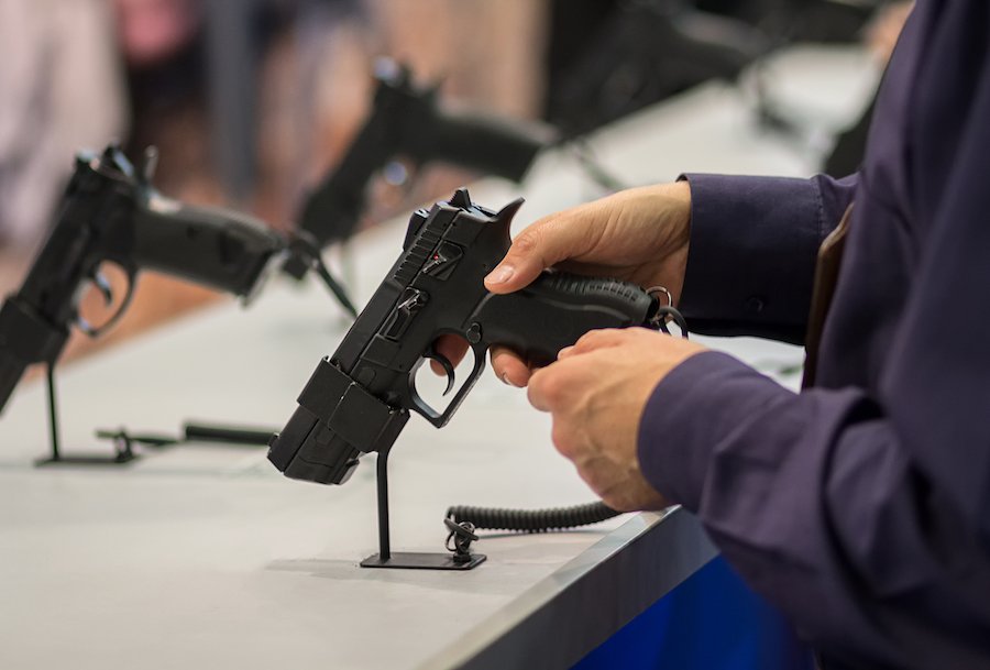 man testing out grip of a gun at gun show