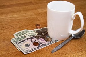 Coffee cup, spoon, and cash tip on a table