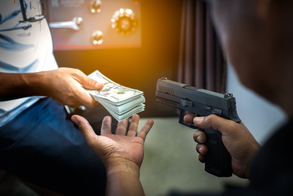 An armed robber pointing a gun.