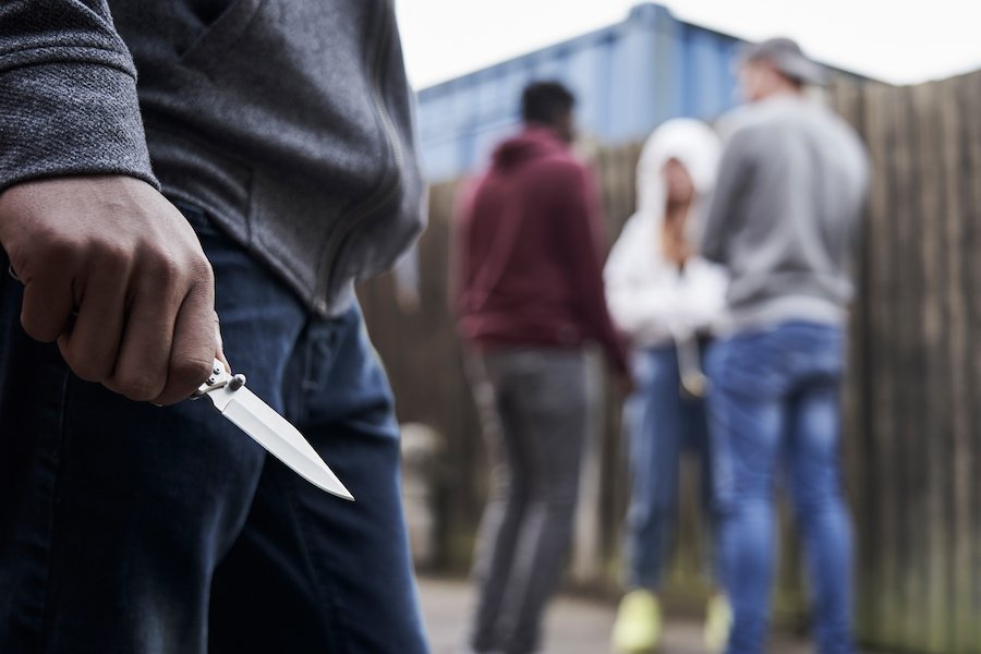 Gang member with knife lurking around three other gang members