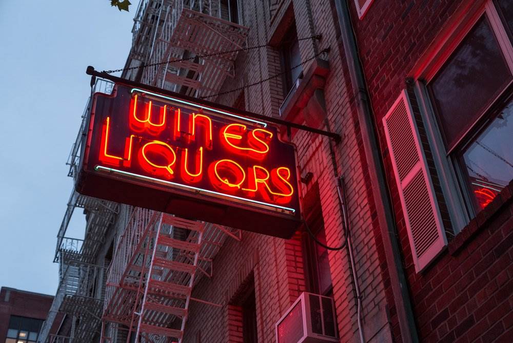 Neon sign of a liquor store on the exterior of a building.