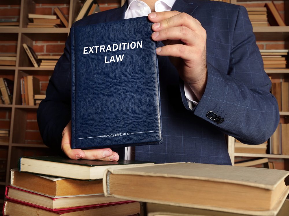 Persona sosteniendo un libro de Ley de Extradición.