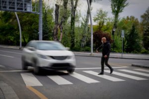 Pedestrian walking into crosswalk with car coming