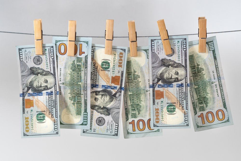 Billetes de cien dólares en una línea de ropa para ilustrar el lavado de dinero