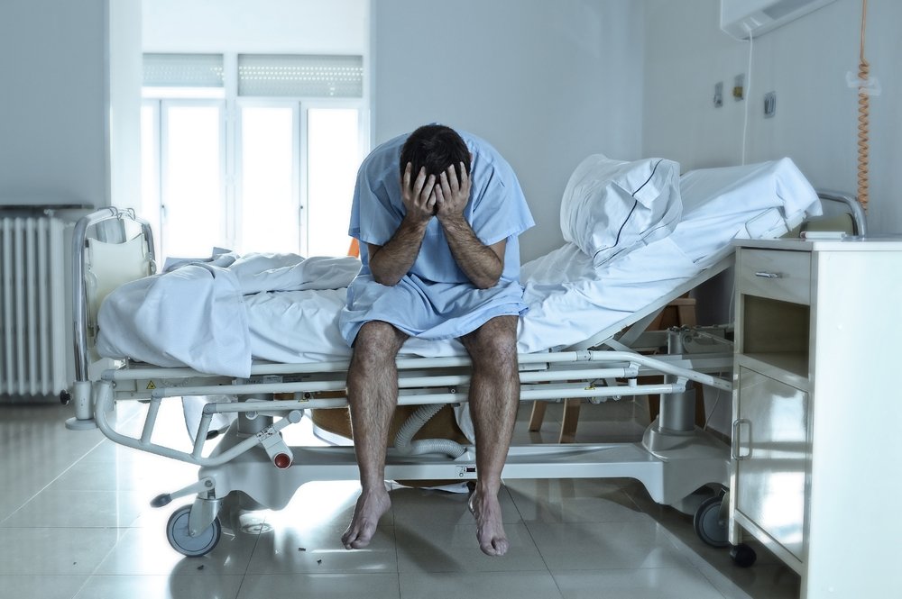 Paciente sentado en la cama del hospital - los daños por dolor y sufrimiento están destinados a compensar a las víctimas por el dolor físico y la angustia mental