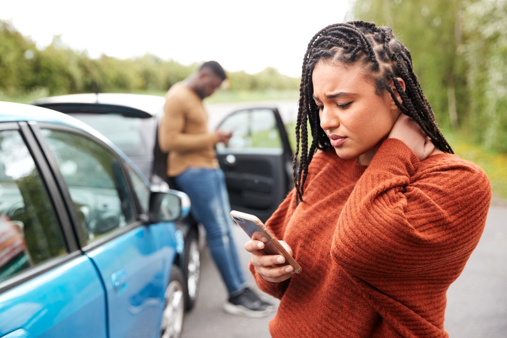 A young on her phone after an accident - our California Uber accident lawyers help victims to sue for damages