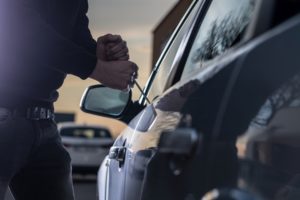 Ladrón rompiendo en el auto para robarlo en violación de CRS 18-4-409