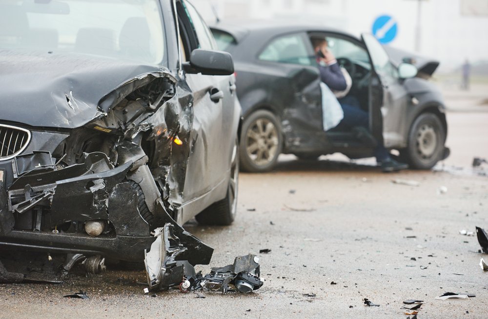 A man on the phone after a bad car crash.