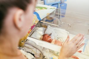 Mother looking at preemie in NICU