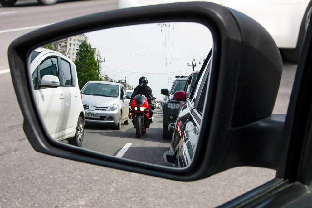 Un motociclista dividiendo carriles - el corte de carril está permitido bajo la ley de California