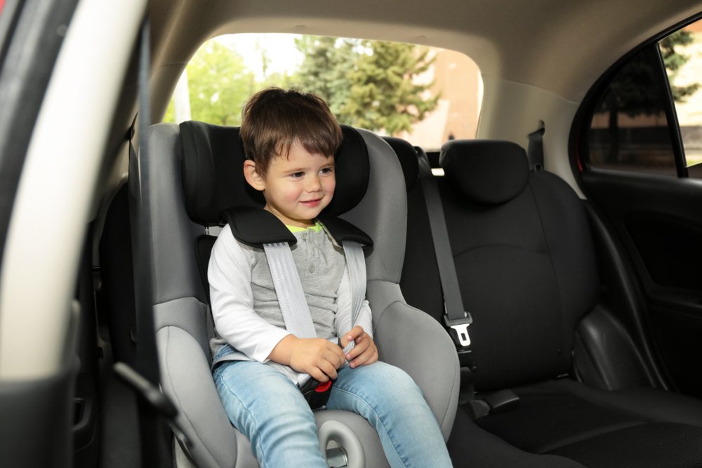 Cute child in the backseat of a car.