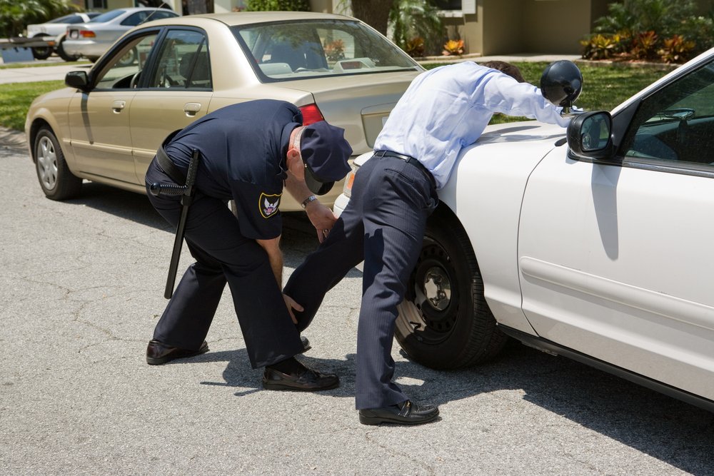 A police officer patting down a suspect - police have limited power to engage in stop-and-frisk in California