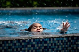 Niño luchando por mantenerse a flote en la piscina