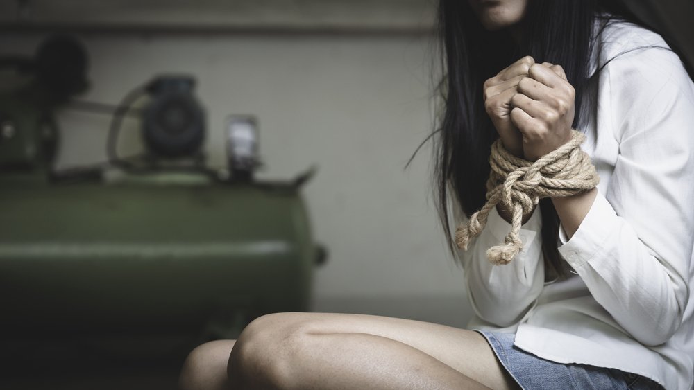 A young girl with arms tied up as an example of false imprisonment