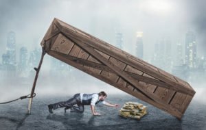 A person crawling into a trap reaching for money.