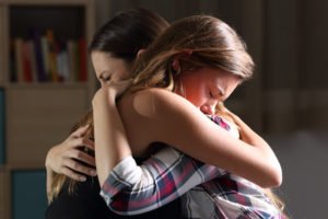 A mother and daughter grieving over the loss of a loved one.