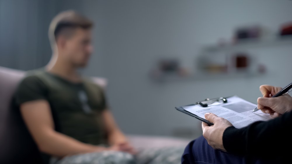 Un veterano hablando con un terapeuta sobre su TEPT.