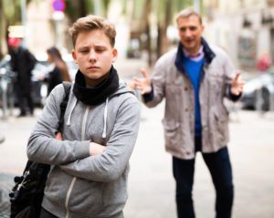 Un hombre mayor tratando de inducir a un niño adolescente en la calle