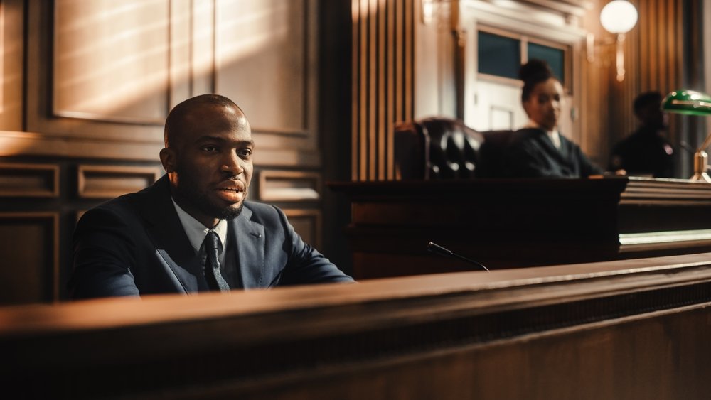 A man testifying seated at the witness stand.