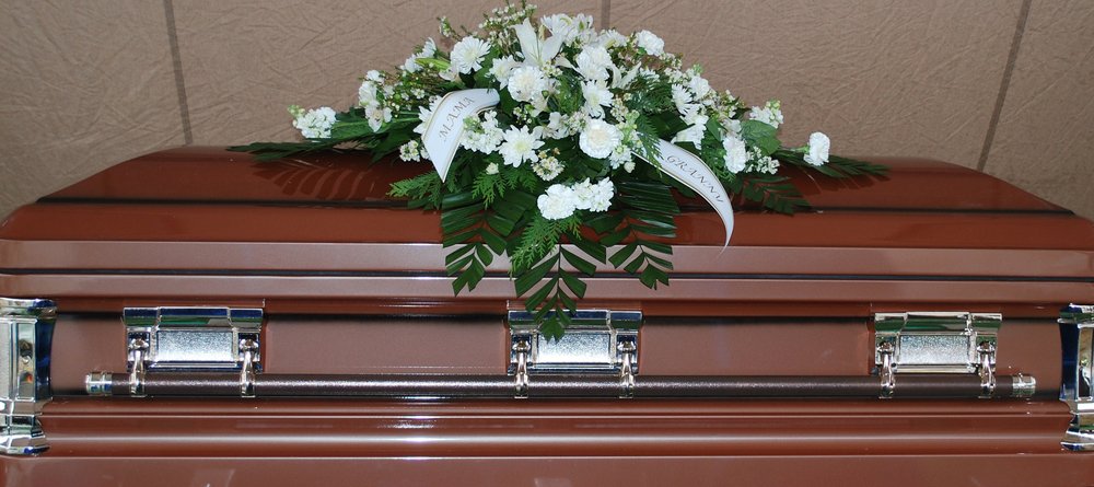 A casket with flowers on top.