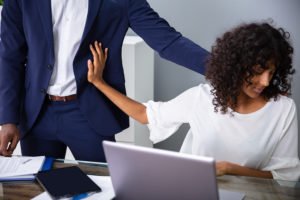 Mujer en la mesa empujando al jefe que la acosa