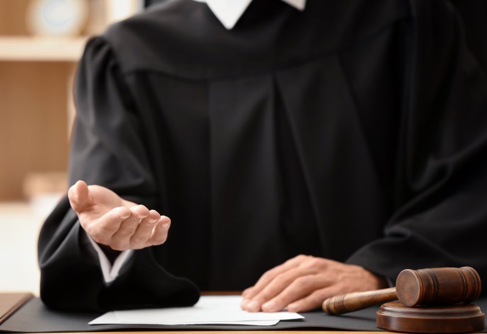 A judge extending his hand as a gesture of requesting money.