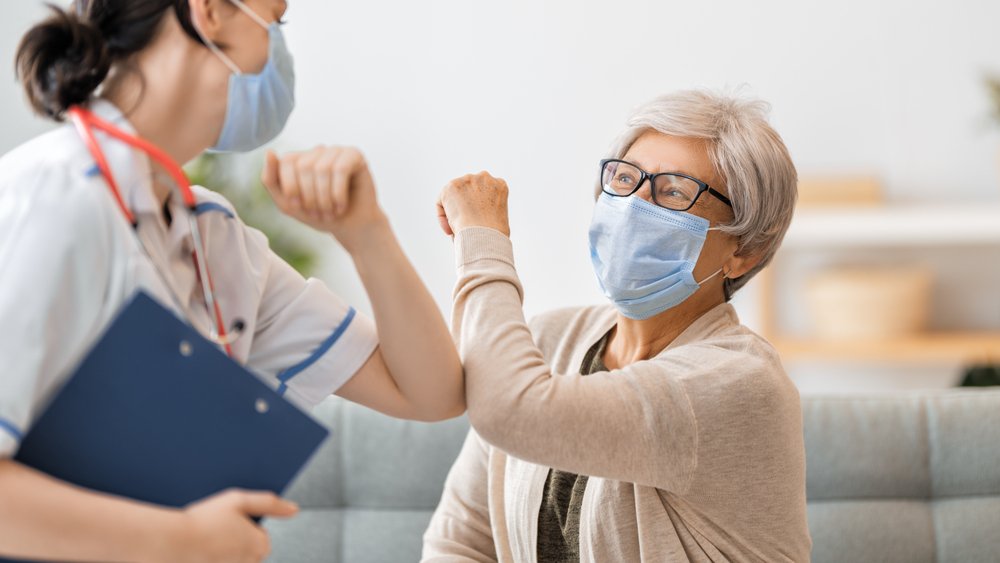 A patient and a nurse giving each other an 'elbow bump.'