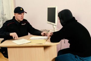 A probation officer having a meeting with a hooded man.