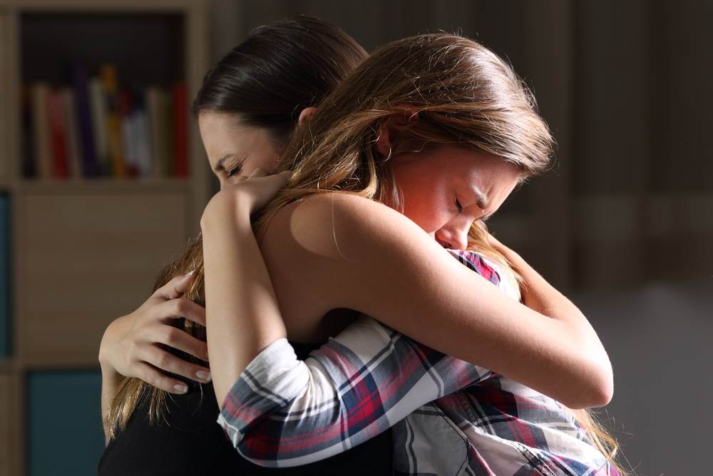 Two women bereaving over the loss of a loved one.