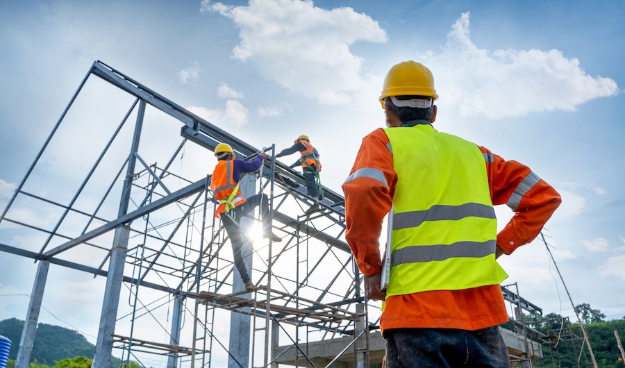 Los trabajadores de la construcción construyendo una estructura al aire libre y ganando salarios de acuerdo con la Orden de Salario 16.