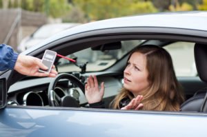 A woman annoyed by the officer's insistence that she blow into a breathalyzer.